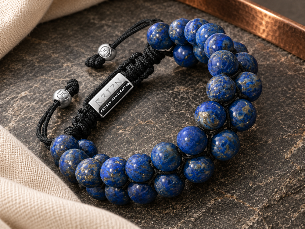 Double-row lapis bracelet on a charcoal tabletop